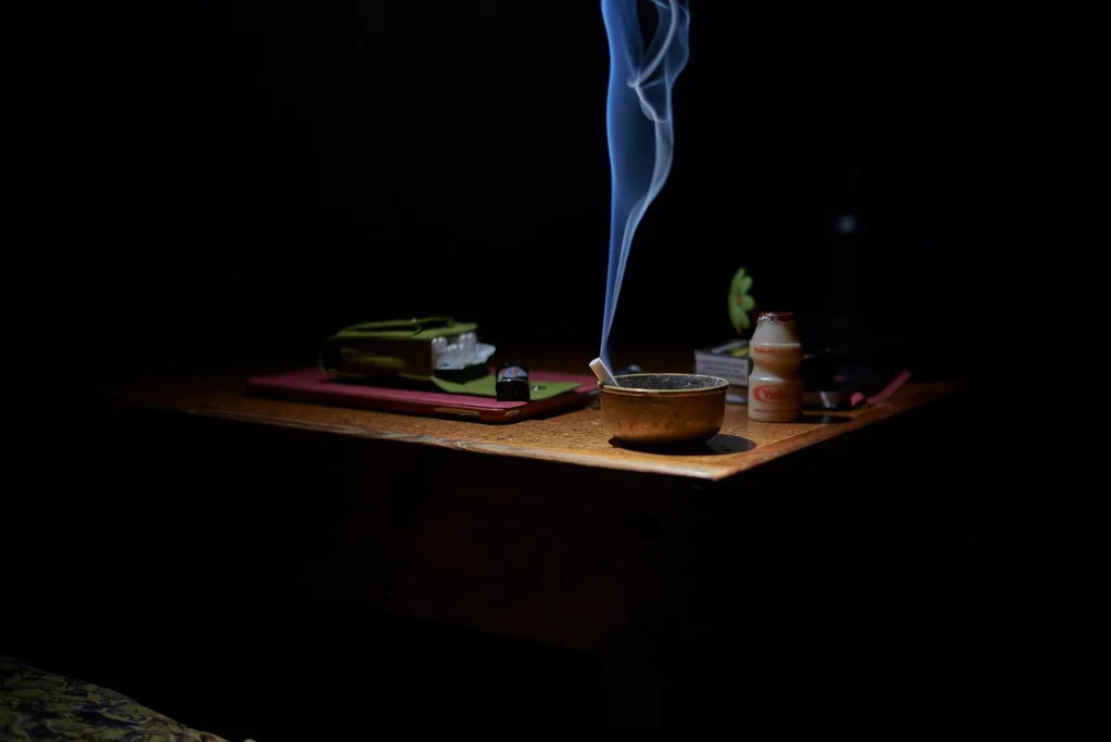 Cigarette allumée dans un cendrier à l'intérieur d'une maison, fumée : comment enlever une odeur de tabac ?
