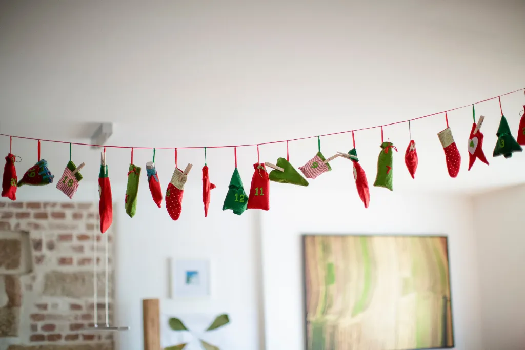 Calendrier de l'avent DYI avec des petits pochons rouges et verts numérotés suspendus à une corde