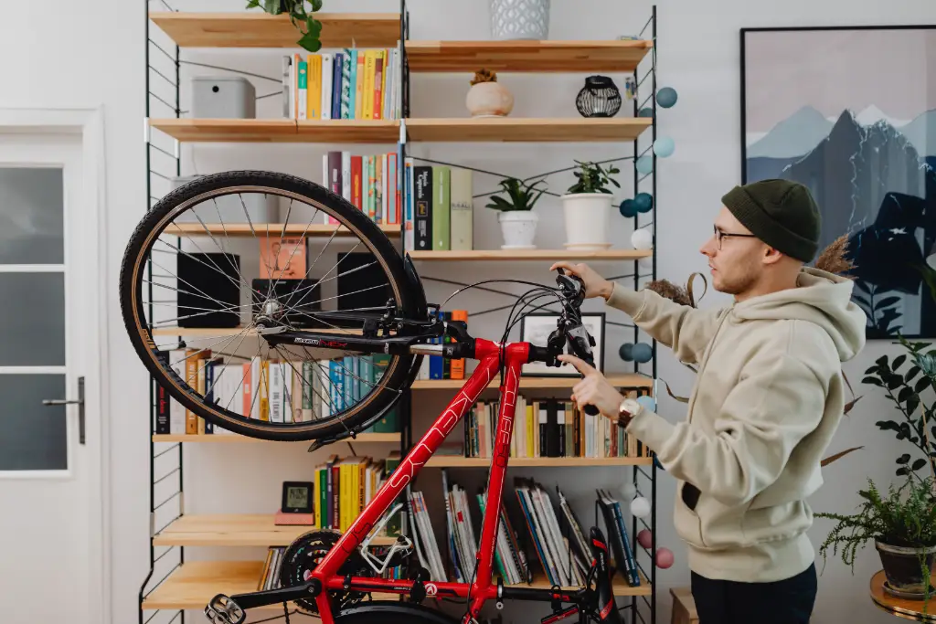 Un homme en train de ranger un vélo dans son appartement